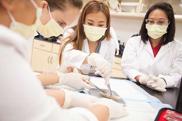 3 students with masks in laboratory